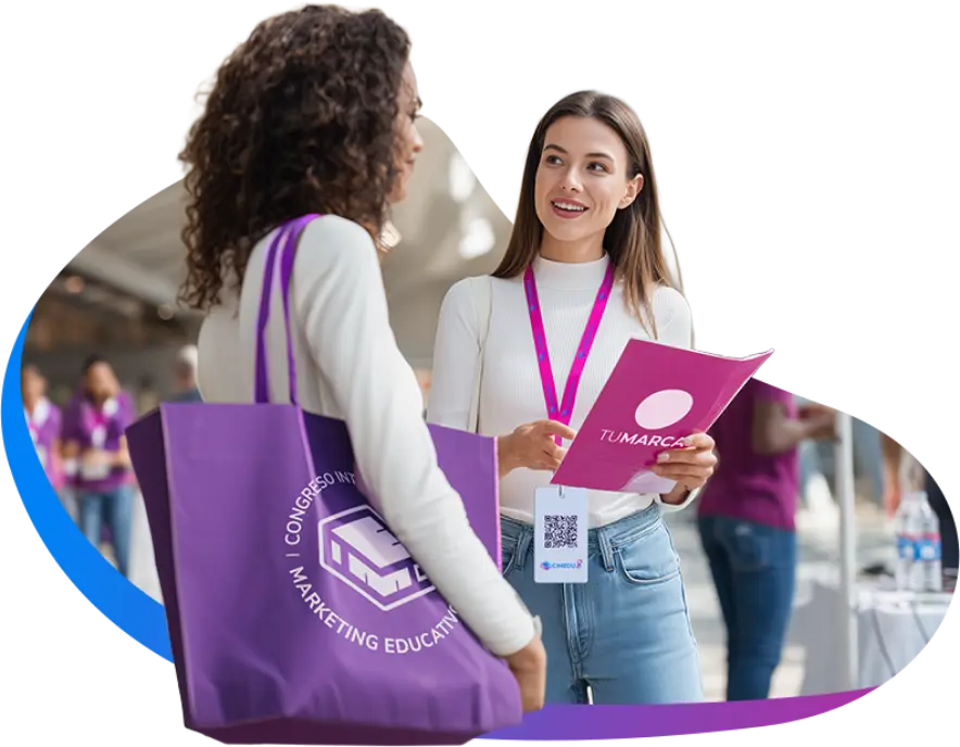 Tú como patrocinador conversando con un prospecto en el área de stands de CIMEDU con un brochure de tu marca.