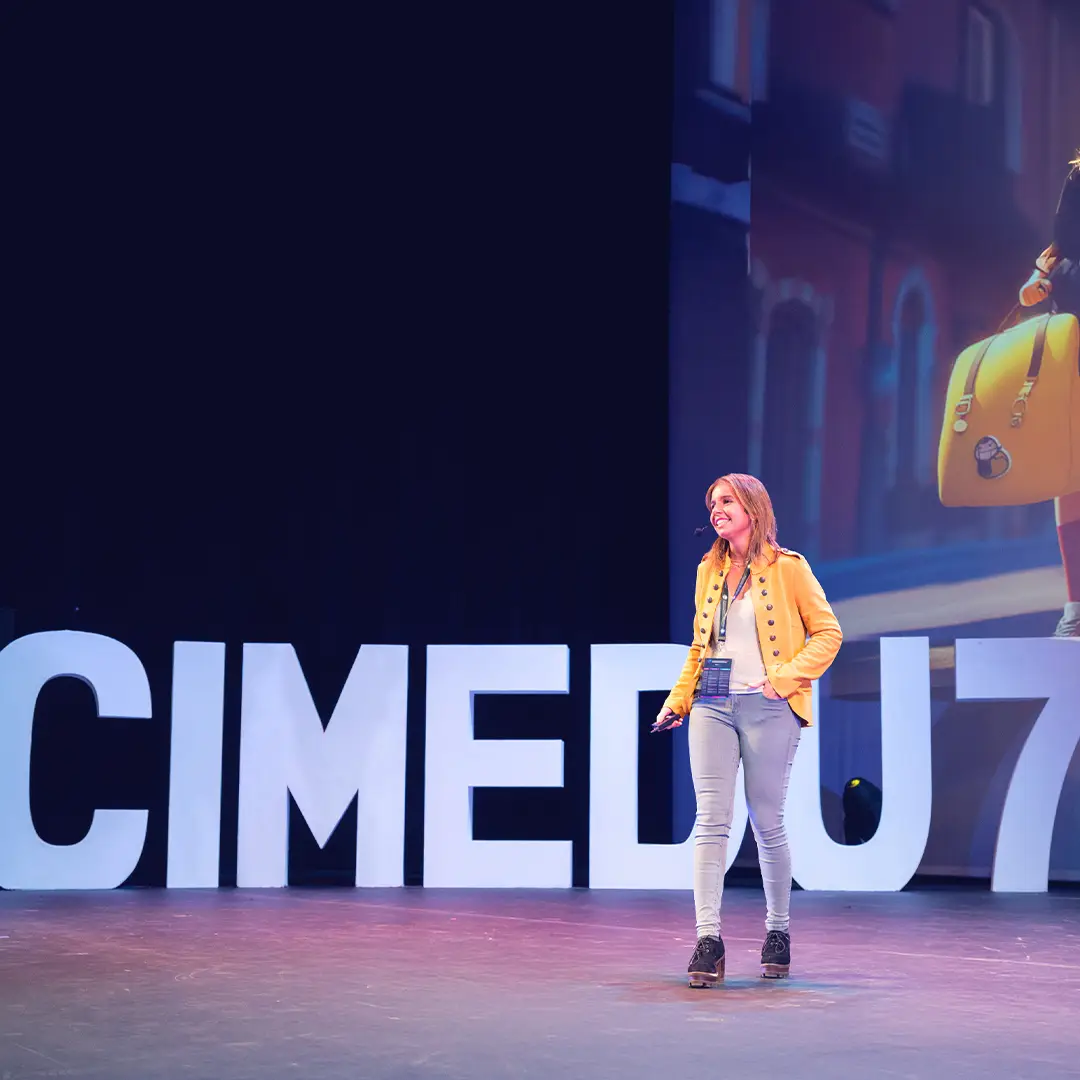 Escenario de CIMEDU con ponente en centro y letras volumétricas
