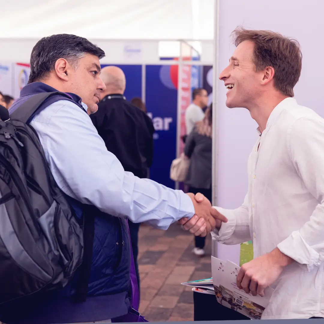 Entrega de brochures a asistentes en zona techada de exposición